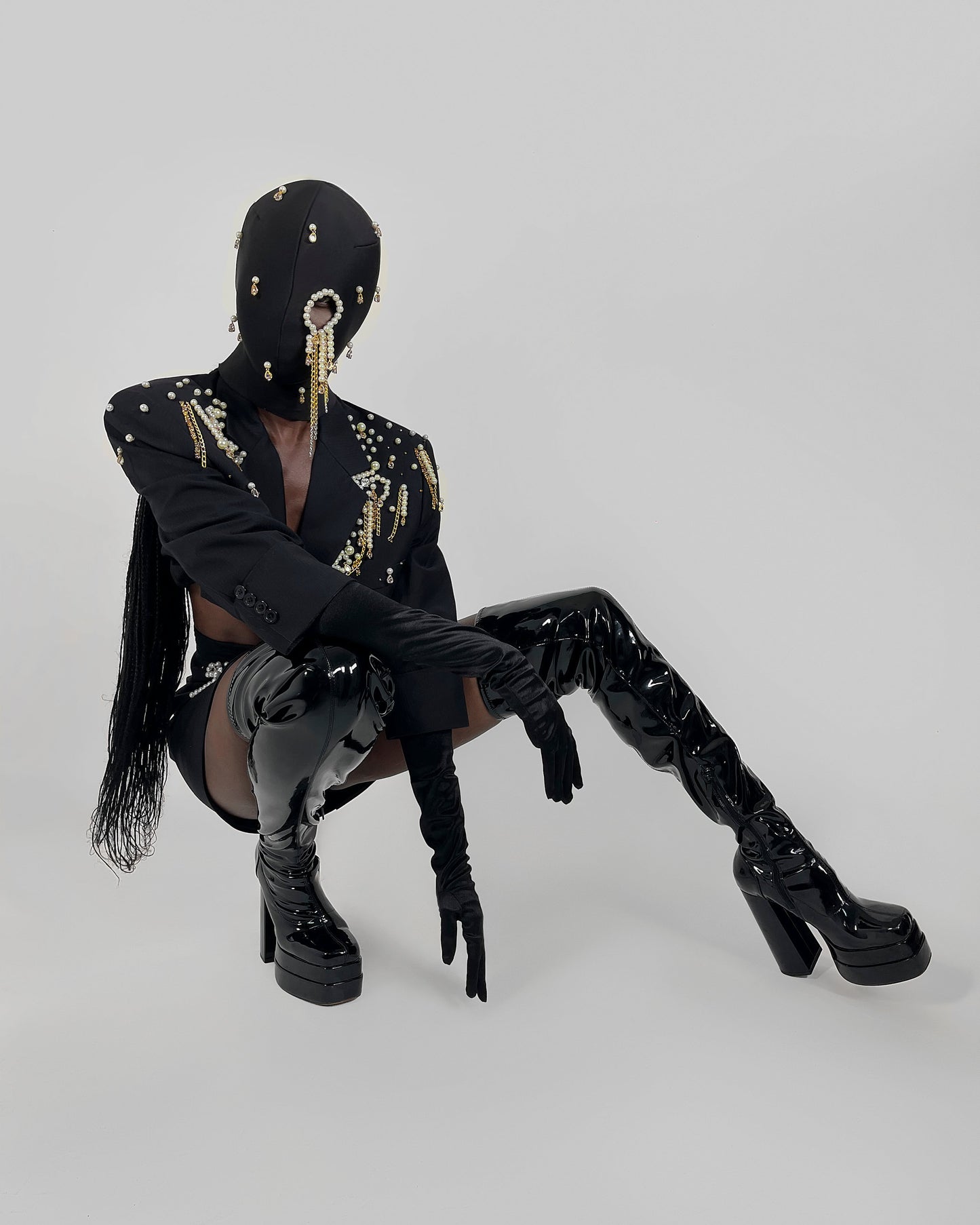 Nadéne luxury black fashion mask with pearls and chains, one eye cut-out design.