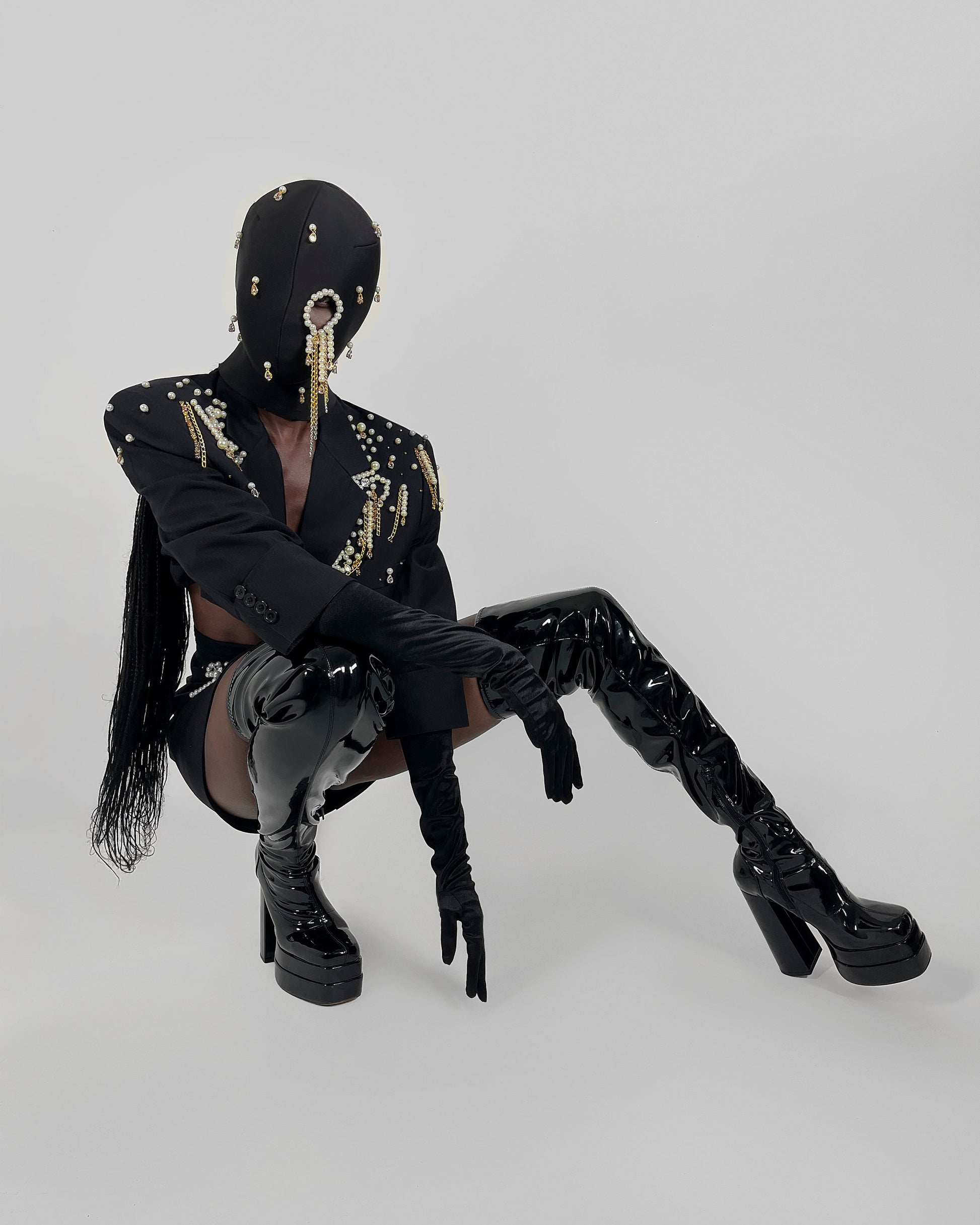 Nadéne luxury black fashion mask with pearls and chains, one eye cut-out design.