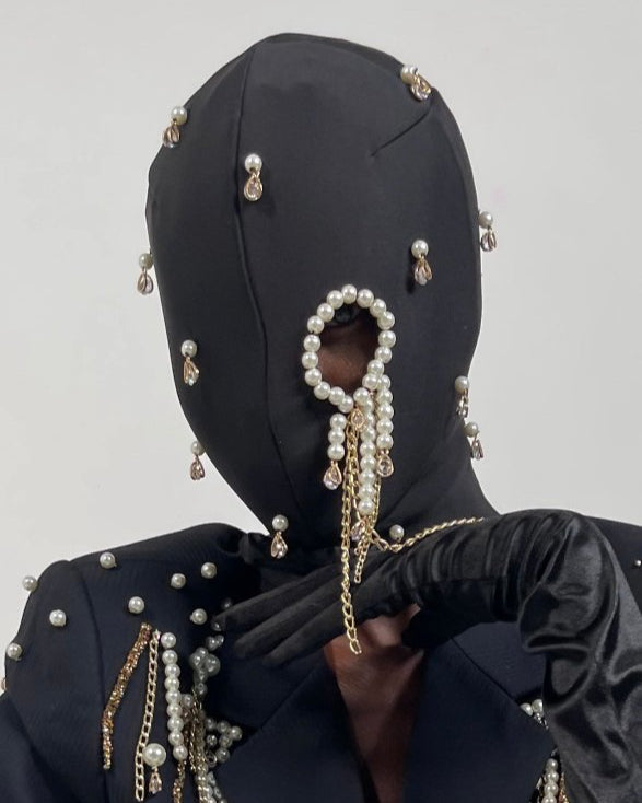 Nadéne luxury black fashion mask with pearls and chains, one eye cut-out design.